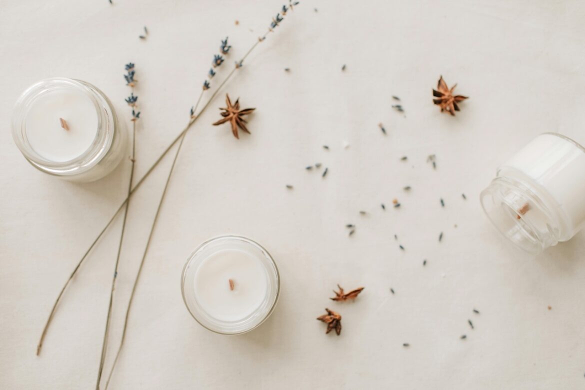 Candles, lavender and cinnamon on a blank surface to invite a moment or stillness where you give yourself permission to tune into your senses. and calm your bervous system.